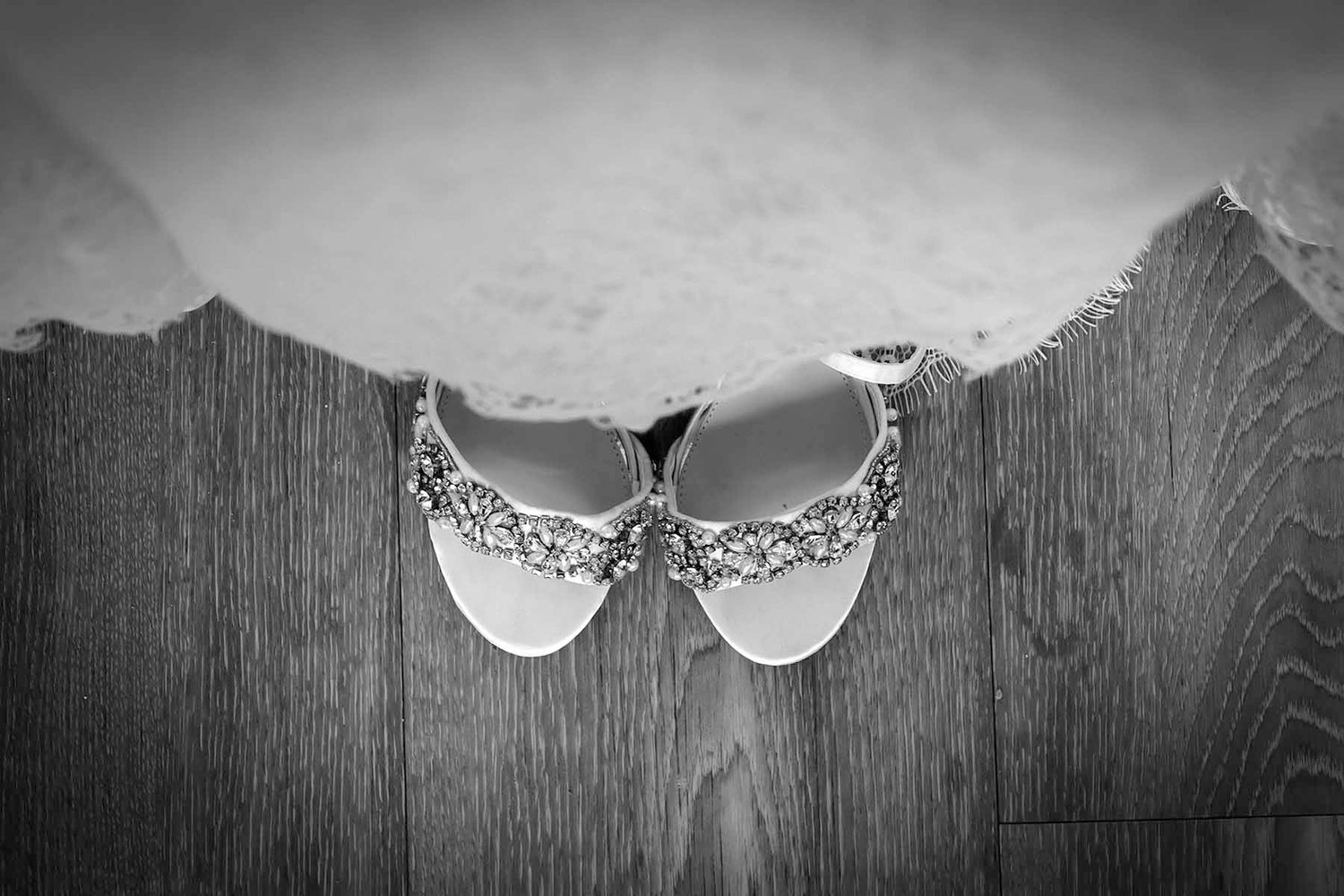 Vintage black and white photo collage showing bridal shoes and decorative lace patterns on a rustic wood background.