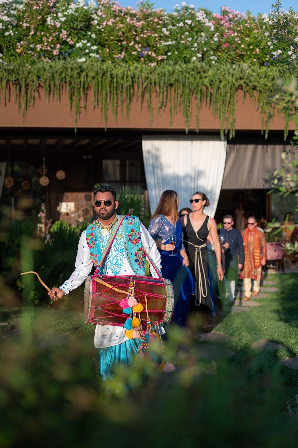 A traditional Dhol player performing in the vineyards of Lake Garda for an Indian celebration