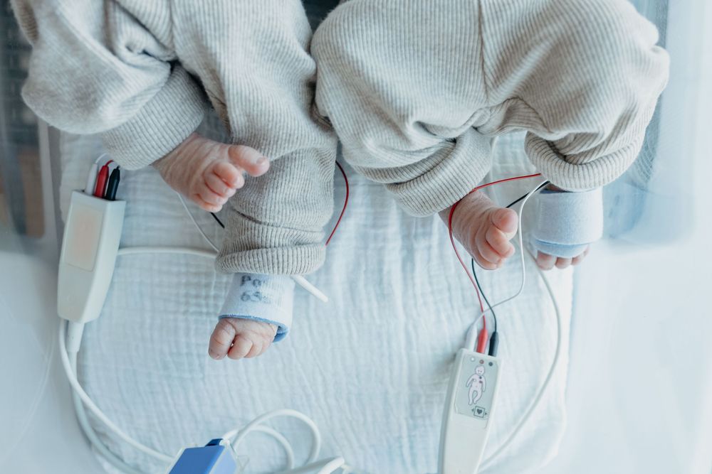 Twin newborns in hospital, closeup of their feet, taken by Jen Knightstep, Photographer