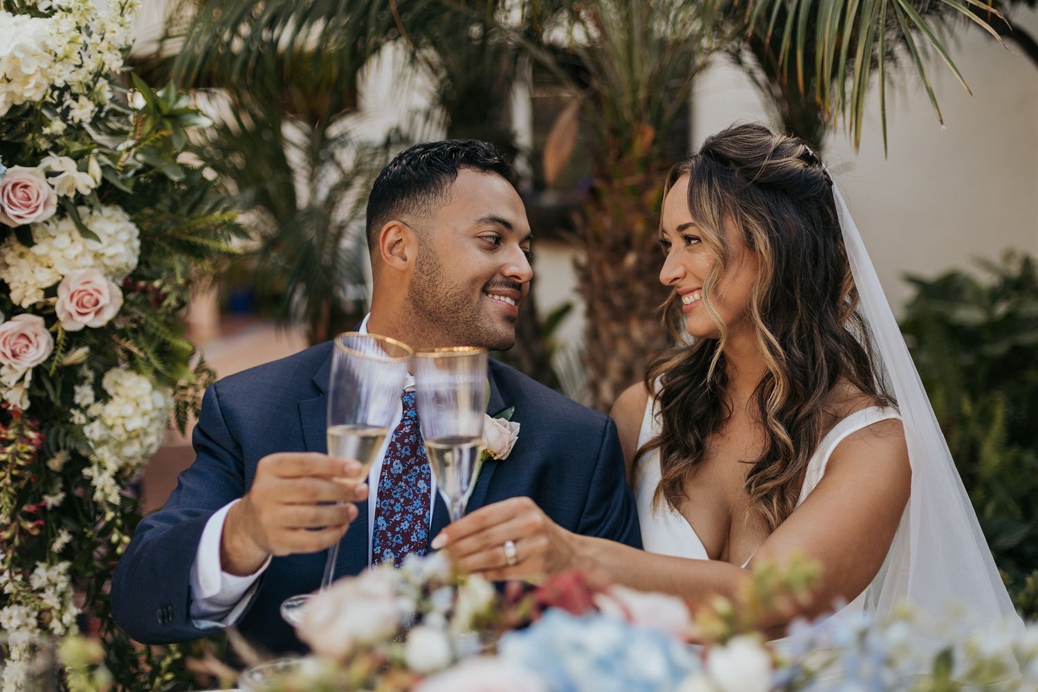 Bride and groom toasting with champagne glasses at outdoor wedding ceremony surrounded by floral arrangements at Darlington House.
