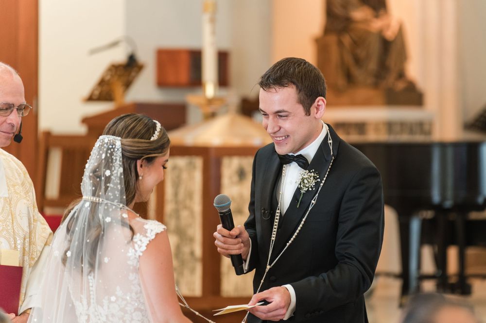 Groom placing ring on bride’s hand during wedding ceremony at Stella Maris Church