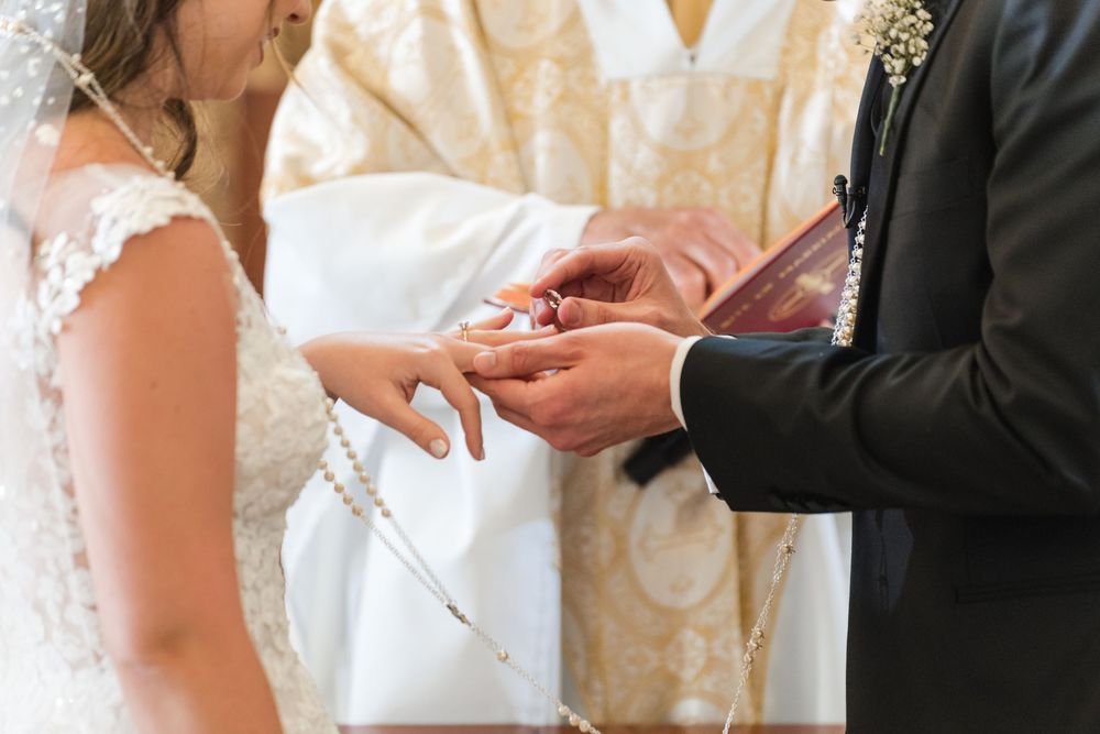Close up of bride and groom exchanging rings during wedding ceremony at Stella Maris Church