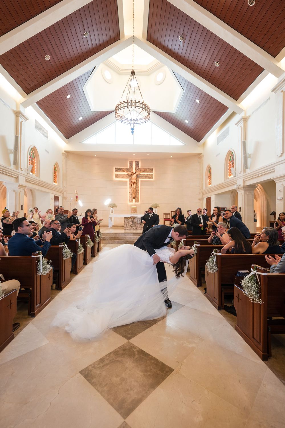 Bride walking down aisle inside Stella Maris Church during wedding ceremony