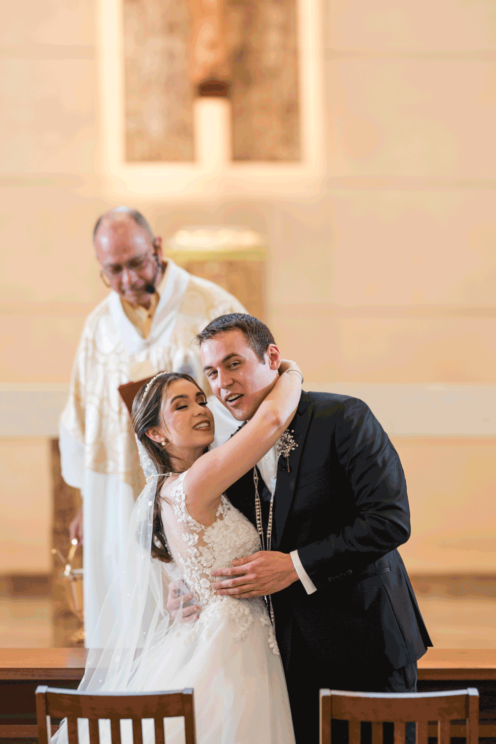 Bride and groom sharing first kiss during wedding ceremony at Stella Maris Church