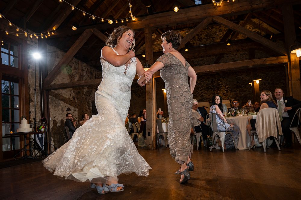 Wedding reception dance floor in a rustic barn venue with string lights overhead creating a romantic atmosphere.