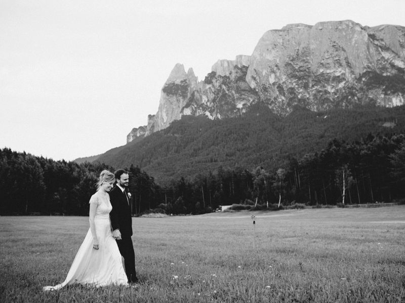 Bride and groom walking together with Dolomites mountain rang