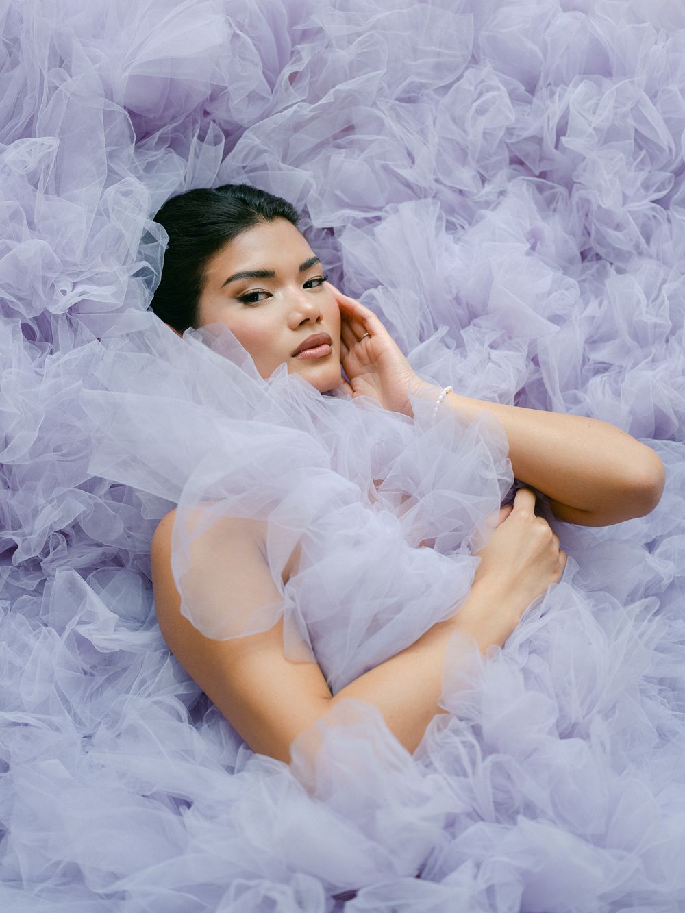 Ethereal fashion photoshoot featuring delicate lavender tulle fabric creating dreamy movement and texture.