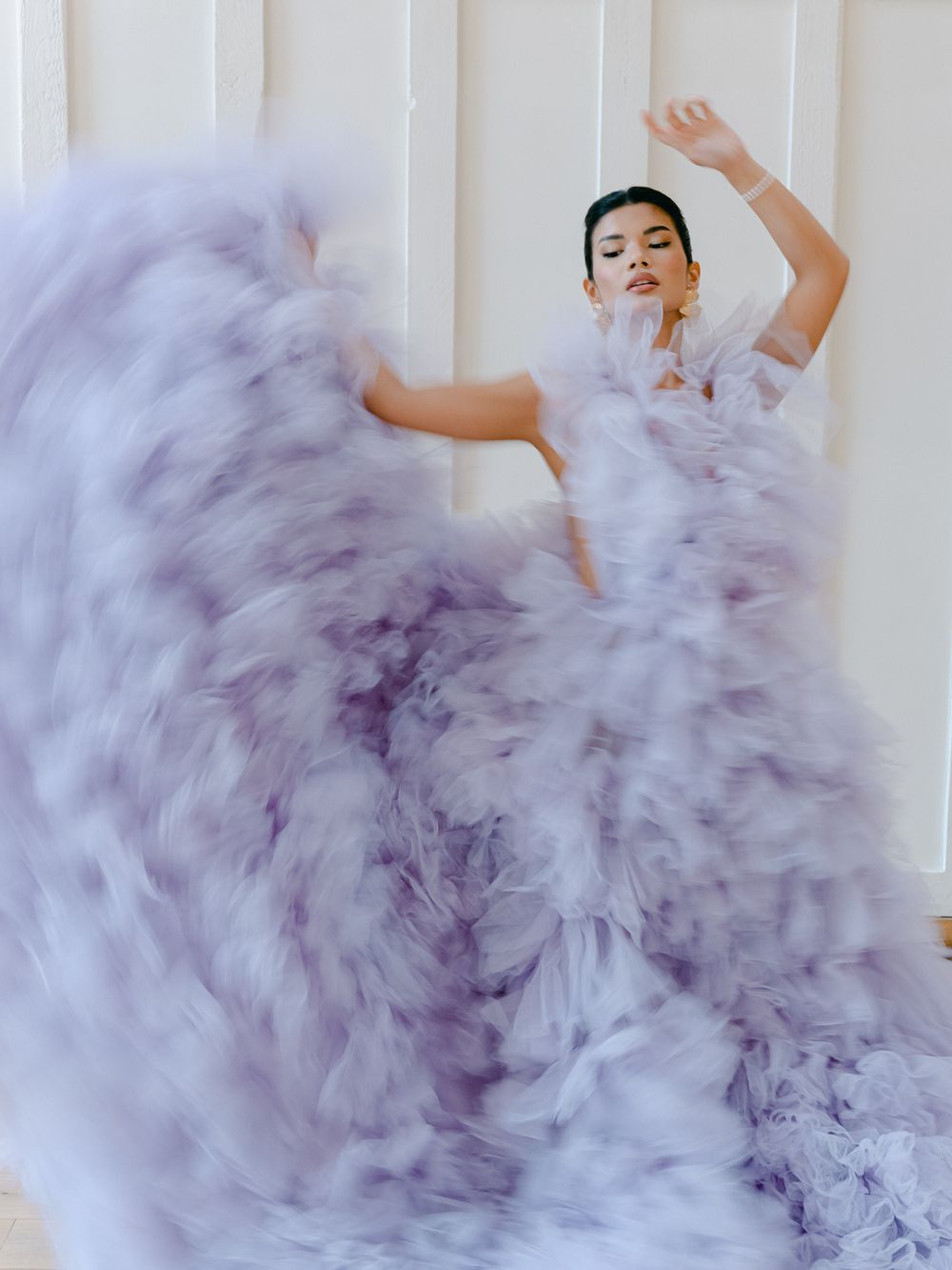 Dynamic motion capture of a lavender dress twirling against a minimalist white background.