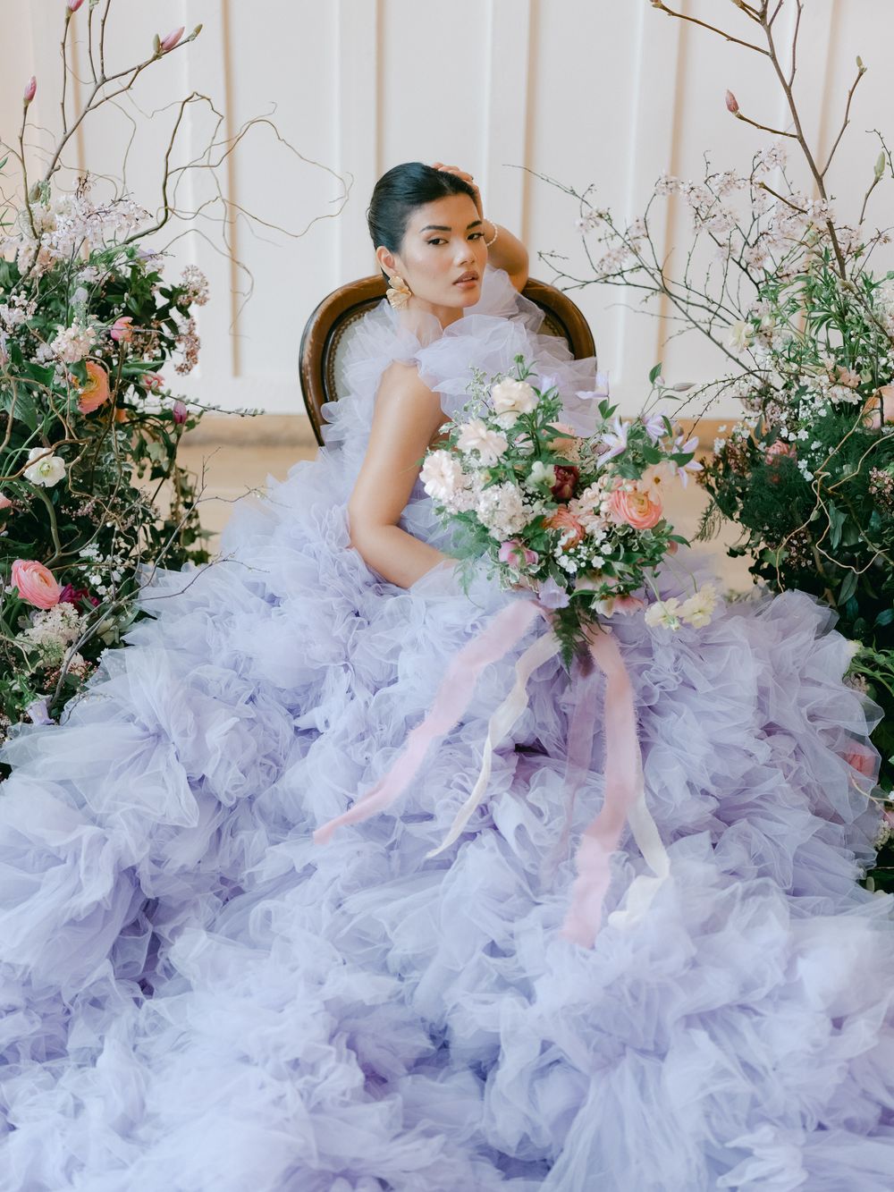 Ethereal lavender tulle gown with floral arrangements creates a romantic garden setting.