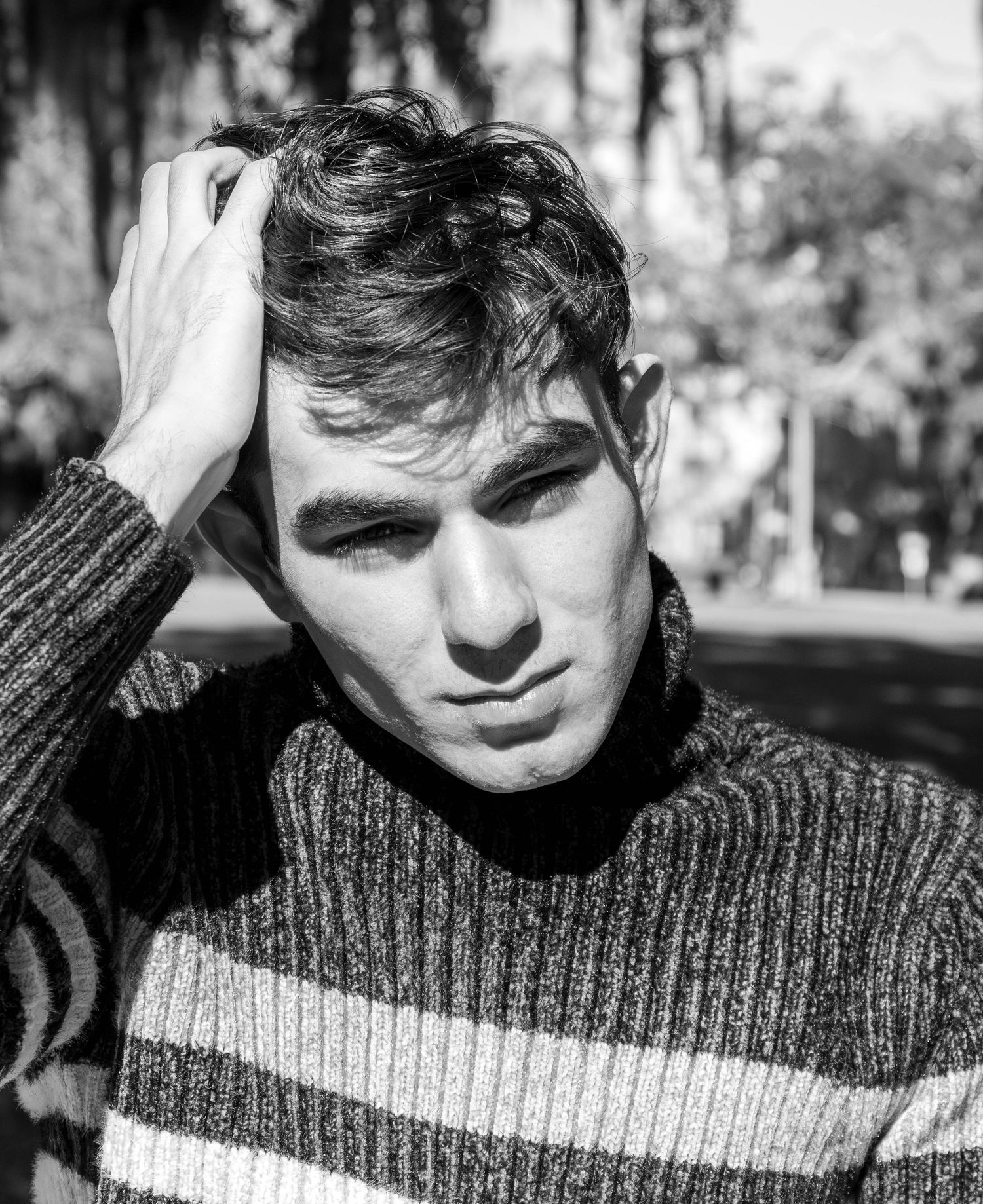 Black and white portrait series showing person in striped sweater with various poses and expressions.