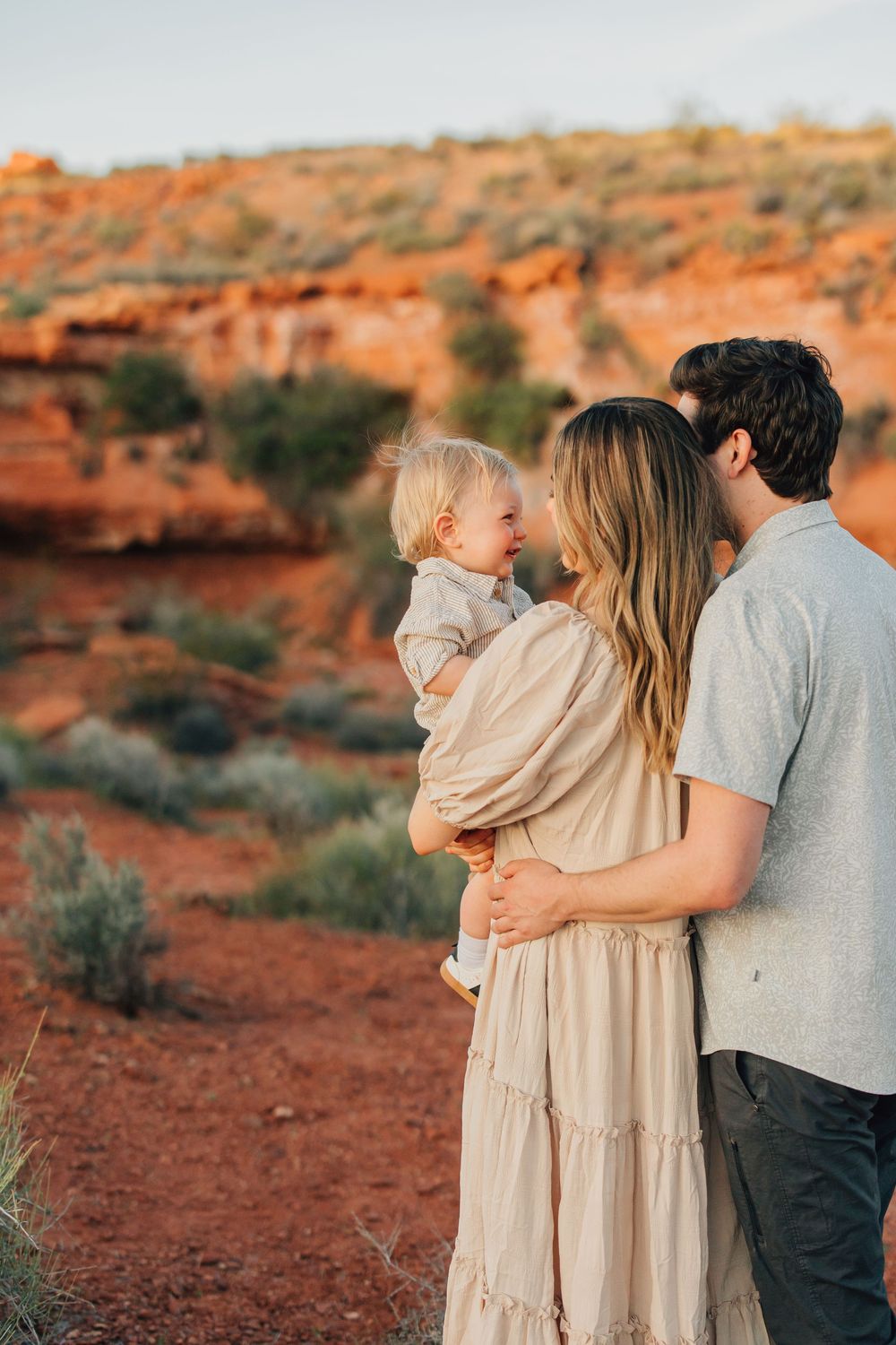 A family enjoying a scenic outdoor adventure, with the parents holding their young child.