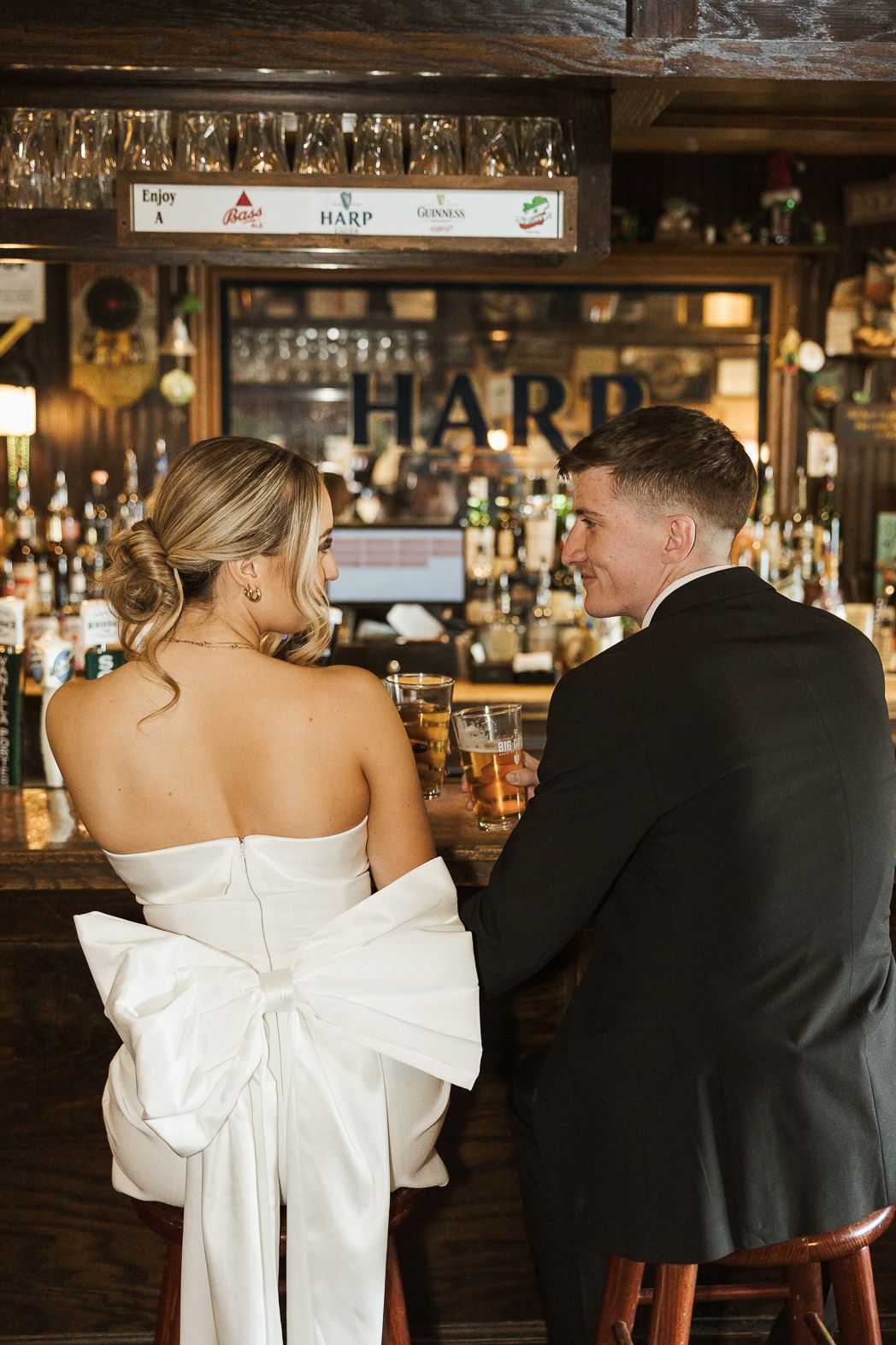 A bride and groom sit together at an elegant bar in a series of romantic candid moments.