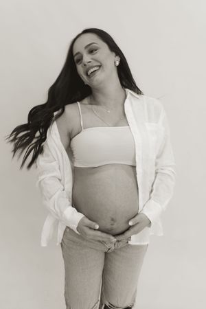 A person in a white button-down shirt poses playfully against a light background.