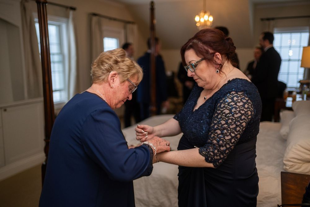 Couples dance together in an elegant room with chandeliers during a formal event.