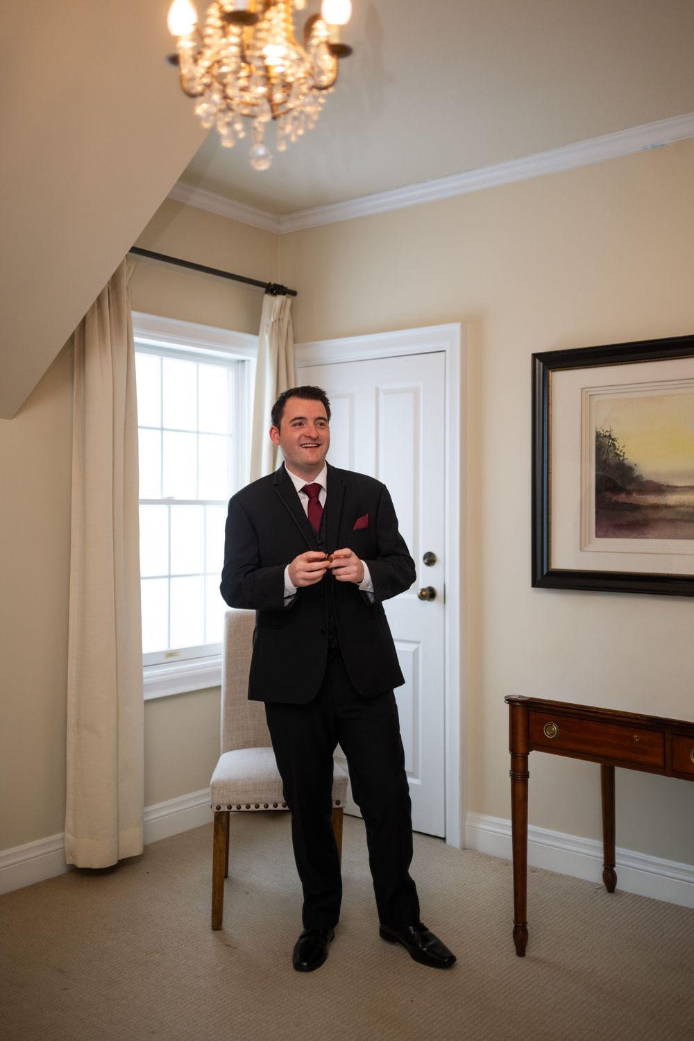 Elegant room with chandelier and white walls showing sequence of formal event preparation.