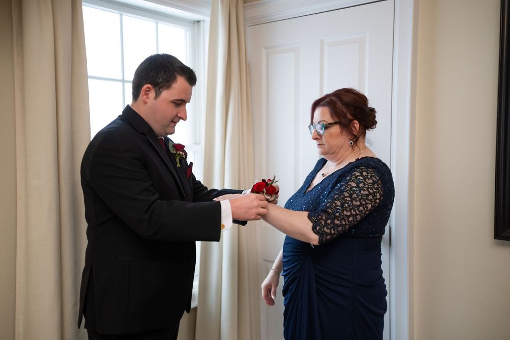 Candid moments captured during a winter wedding in an elegant room with large windows.