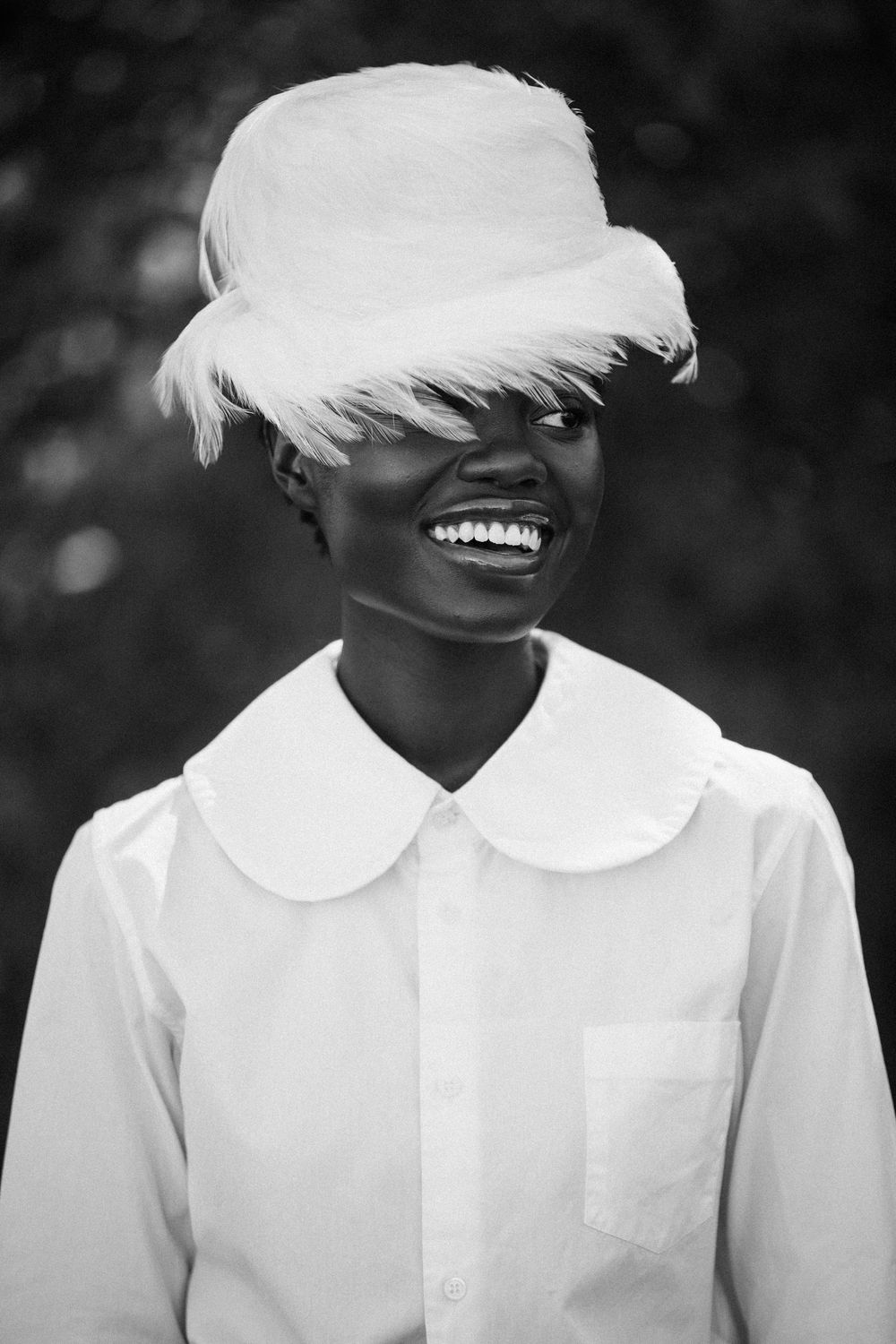 A black and white artistic series of portraits showing a person wearing a white collared shirt with a white feather covering their face.