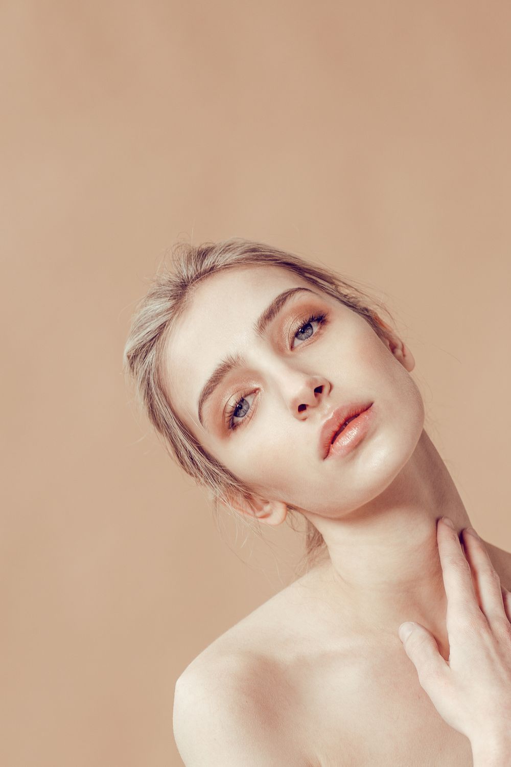 Artistic portrait series showing graceful poses against a beige background with soft lighting and minimalist styling.