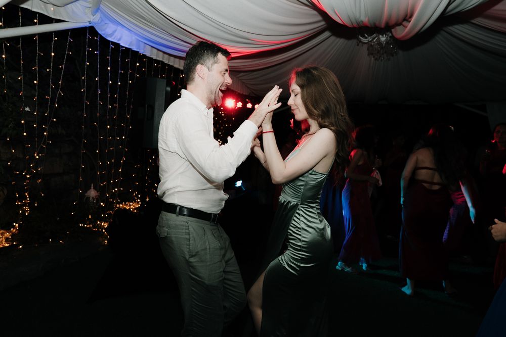 Guests dancing under the DJ's lights during the evening wedding reception in Imperia.