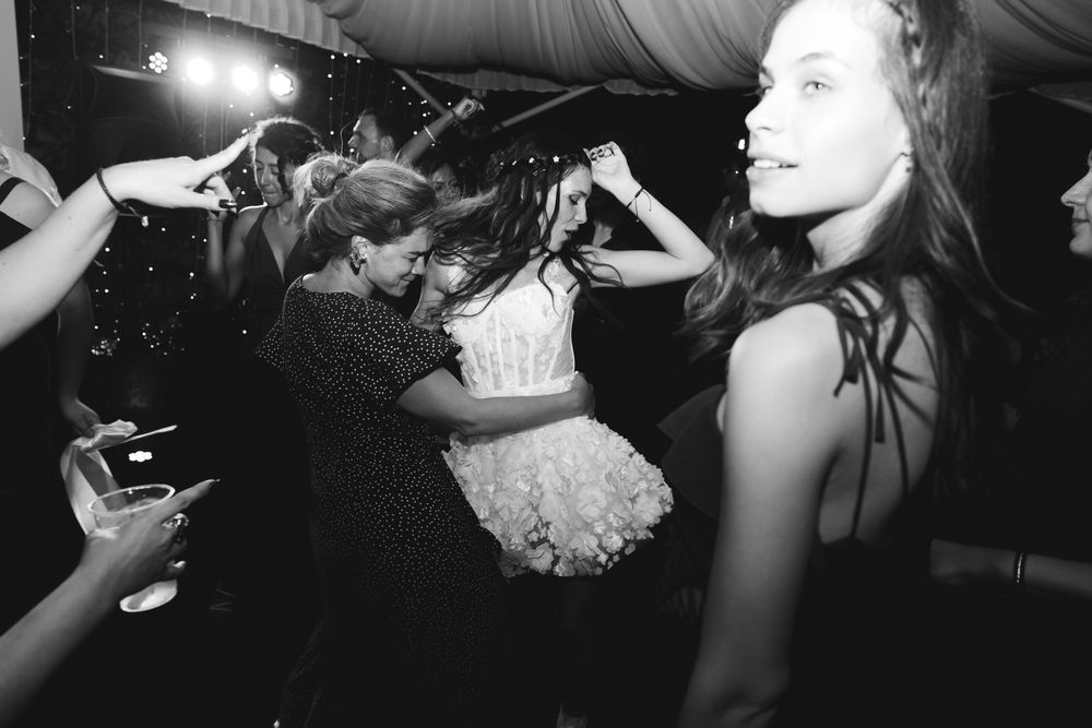 Bride dancing wildly with friends during black and white wedding party at Villa Casa Rossa
