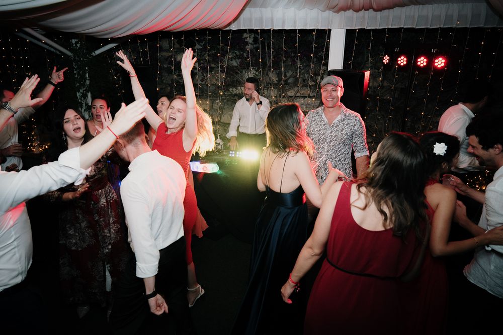 Group party during the evening reception with DJ and stage lighting at Villa Casa Rossa in Imperia.