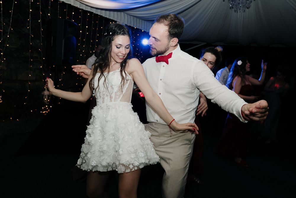 Bride and groom dancing together during the evening wedding party at Villa Casa Rossa with disco lights.