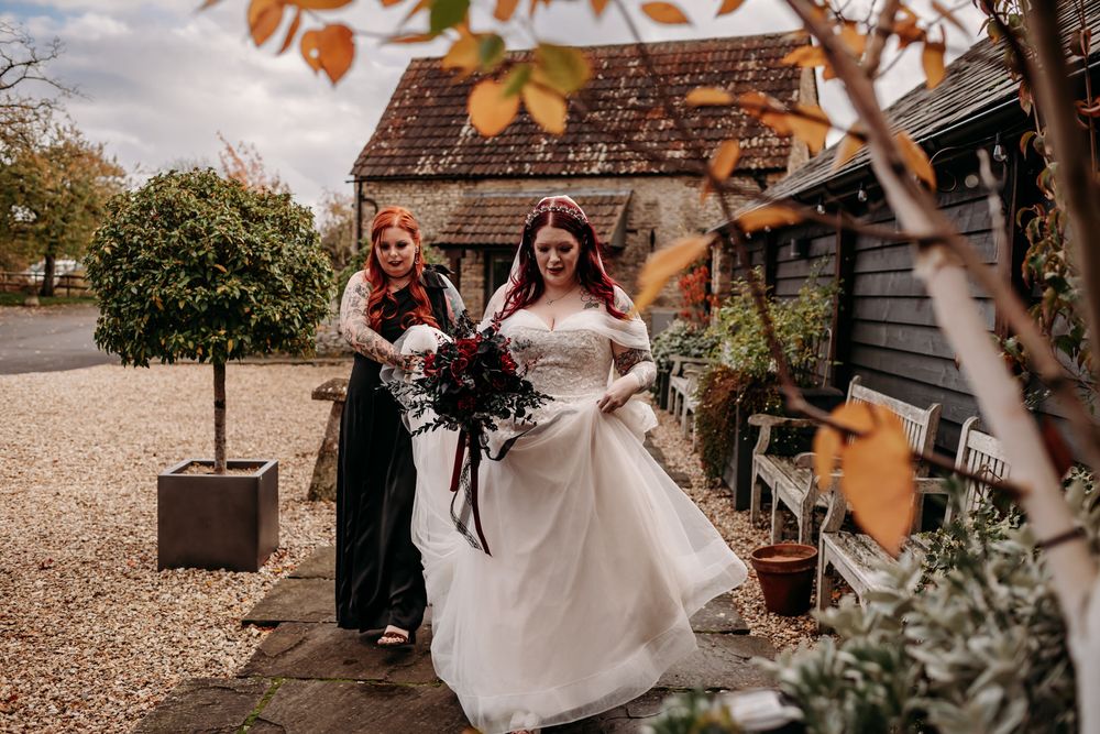 A wedding celebration at a rustic barn venue with autumn leaves and natural decor in warm fall colors.