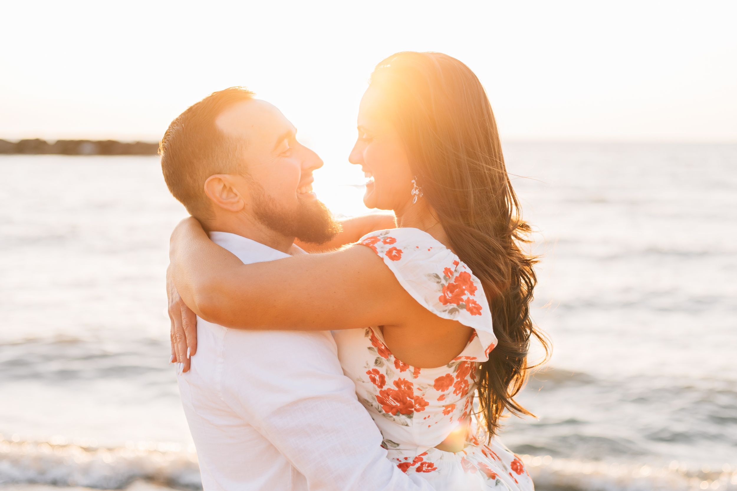 A romantic sunset embrace between a couple on the beach.