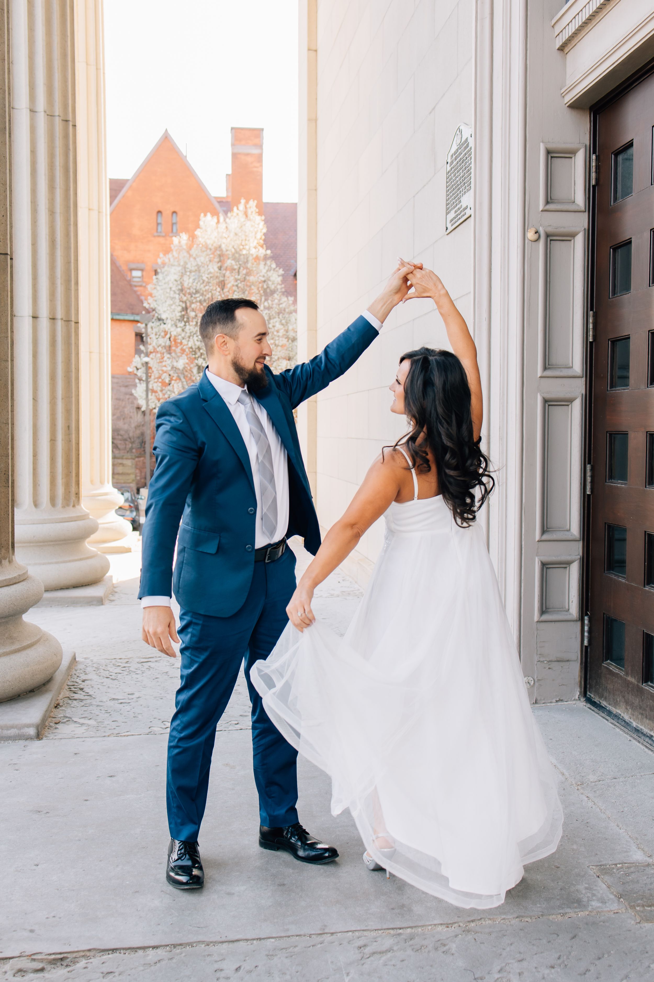A couple dancing on classic architecture steps, with the bride's dress flowing.