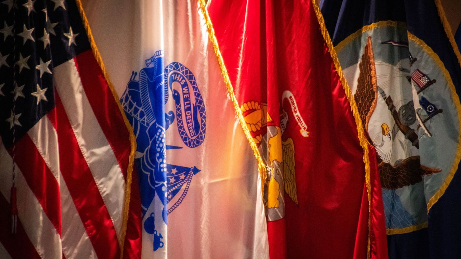 Portcall Productions artistic background imagery capturing the patriotic atmosphere and pageantry of a joint military service ceremony."