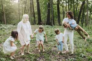 Group enjoying a playful moment together in a sunlit woodland clearing surrounded by lush greenery.