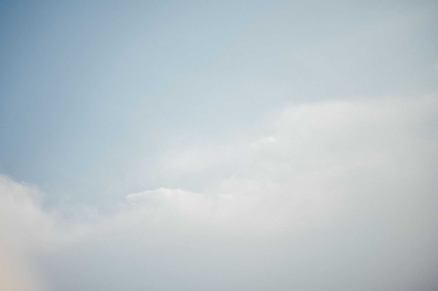 Light clouds against a soft blue sky in a minimalist composition.