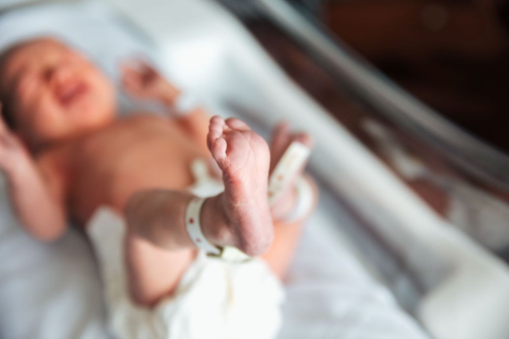 Newborn baby lying in hospital bassinet with ID bracelet on tiny feet after birth. fresh 48, Newport Hospital