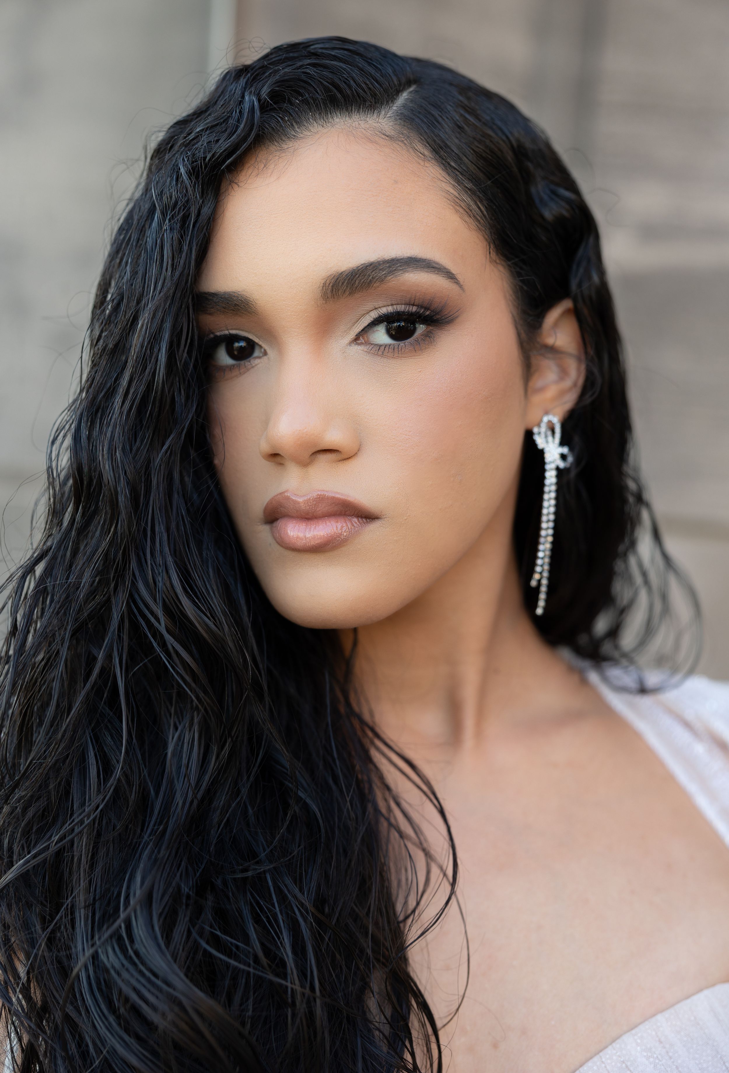 Close-up beauty portrait showing dangling crystal earrings and glamorous evening makeup.