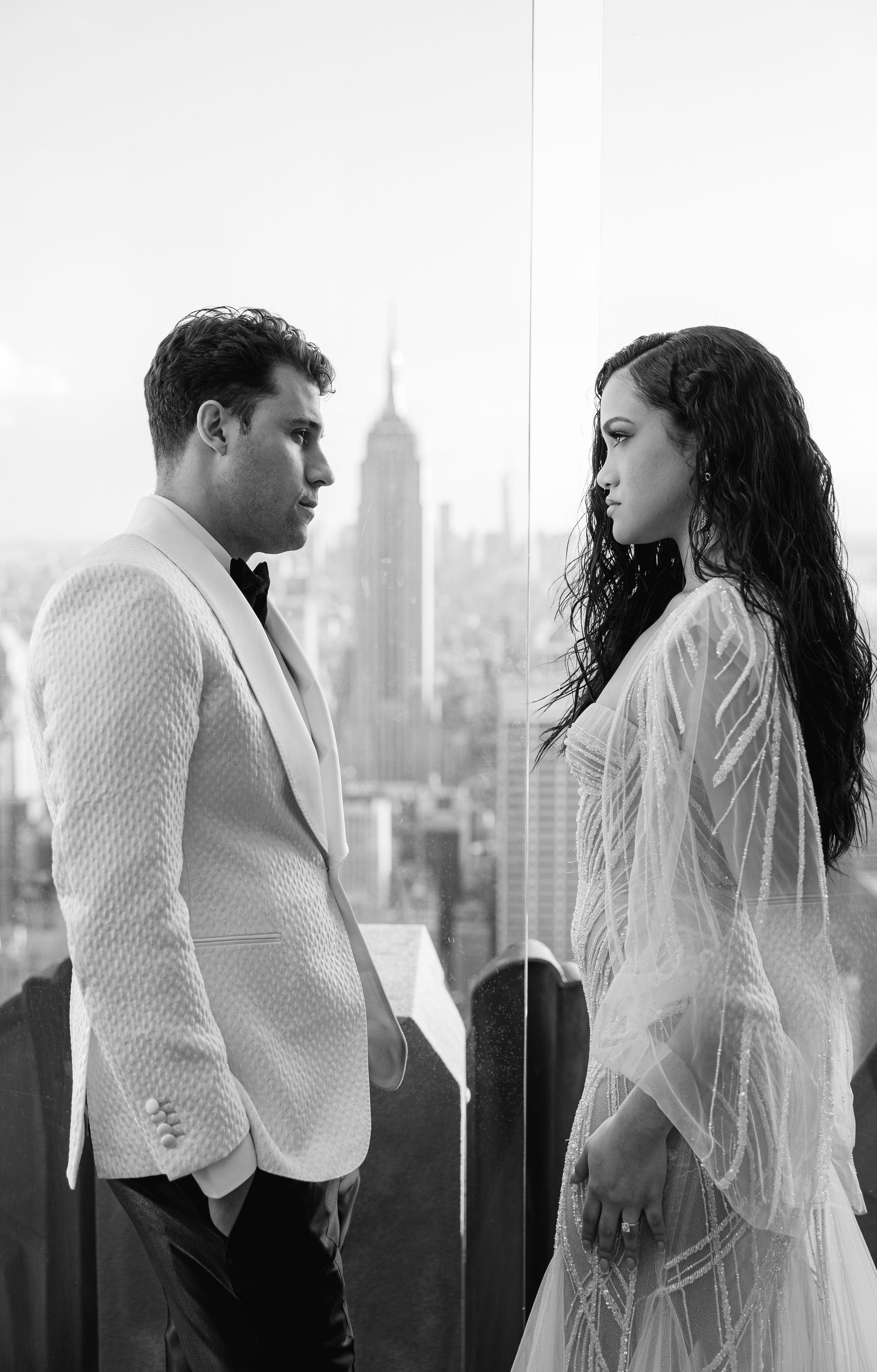 Black and white portrait of couple in formal attire against Manhattan skyline backdrop.