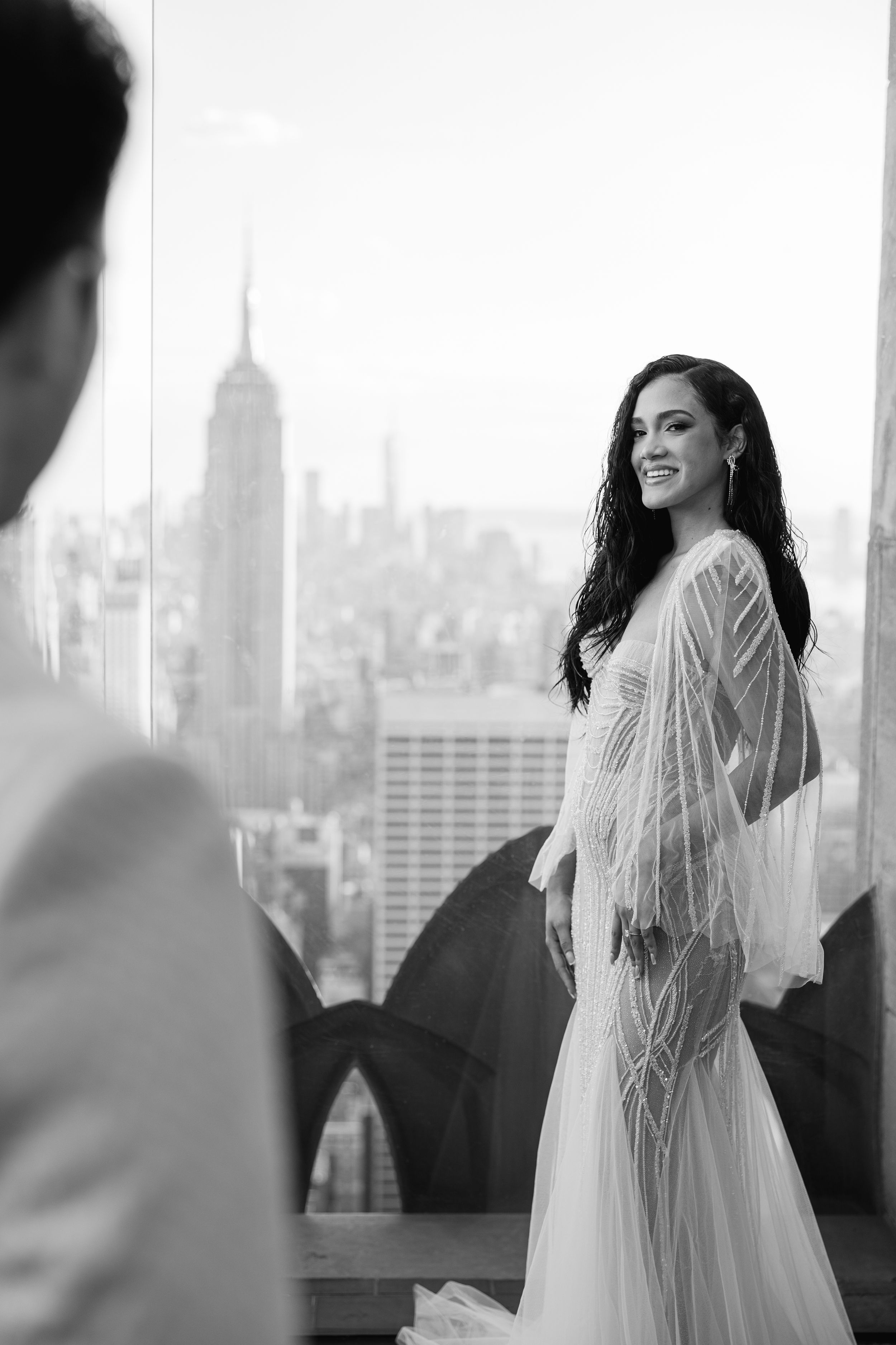 Black and white candid moment with Manhattan skyline featuring Empire State Building.