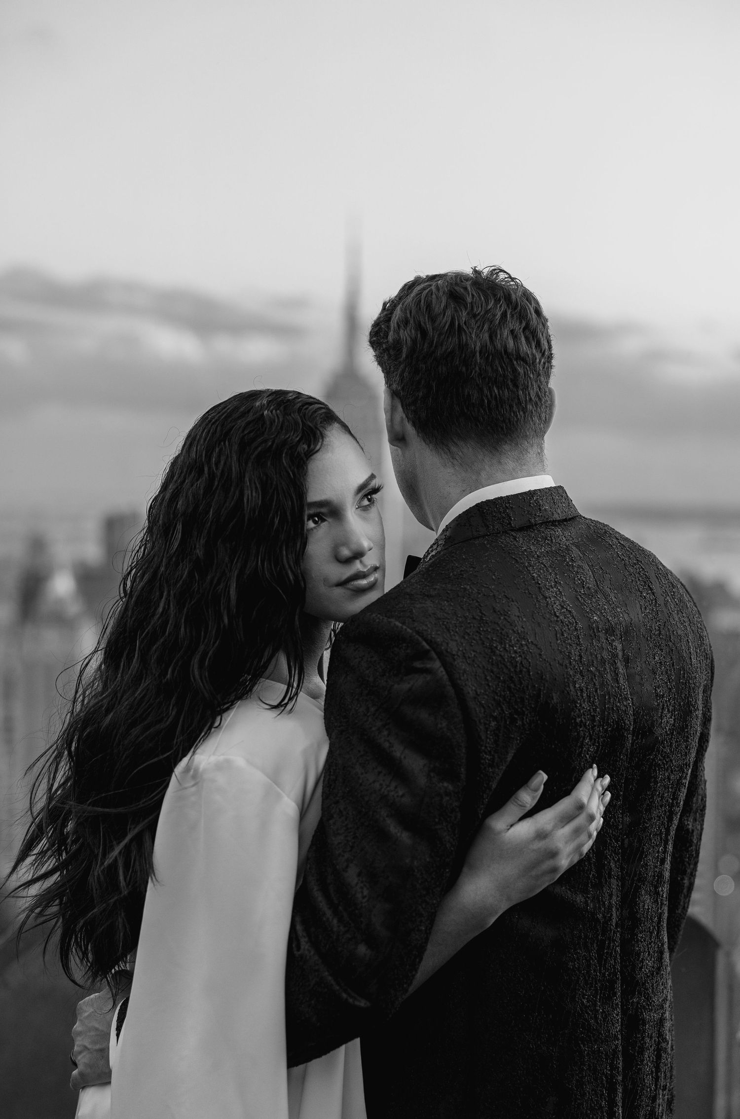 Black and white intimate wedding portrait on a city rooftop.