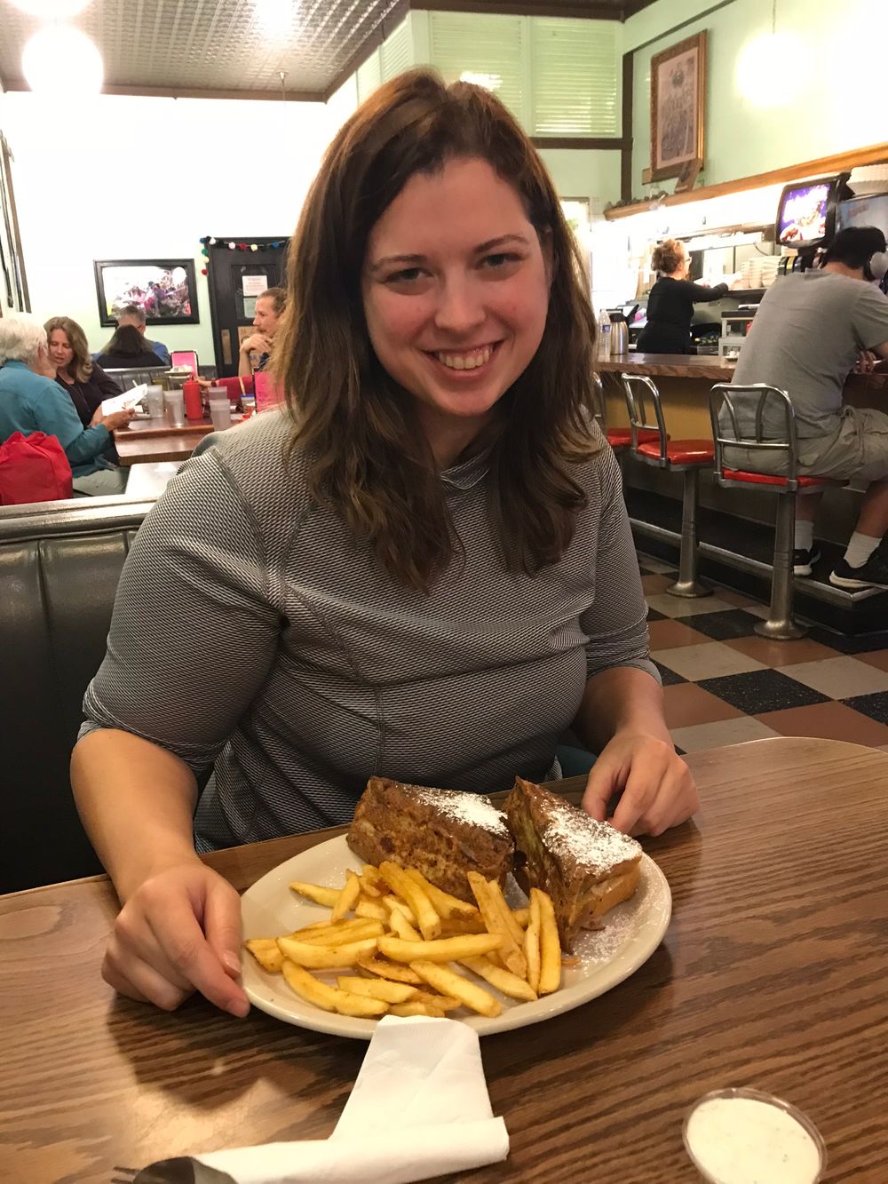 Restaurant diner enjoying a sandwich with french fries at a casual dining establishment.