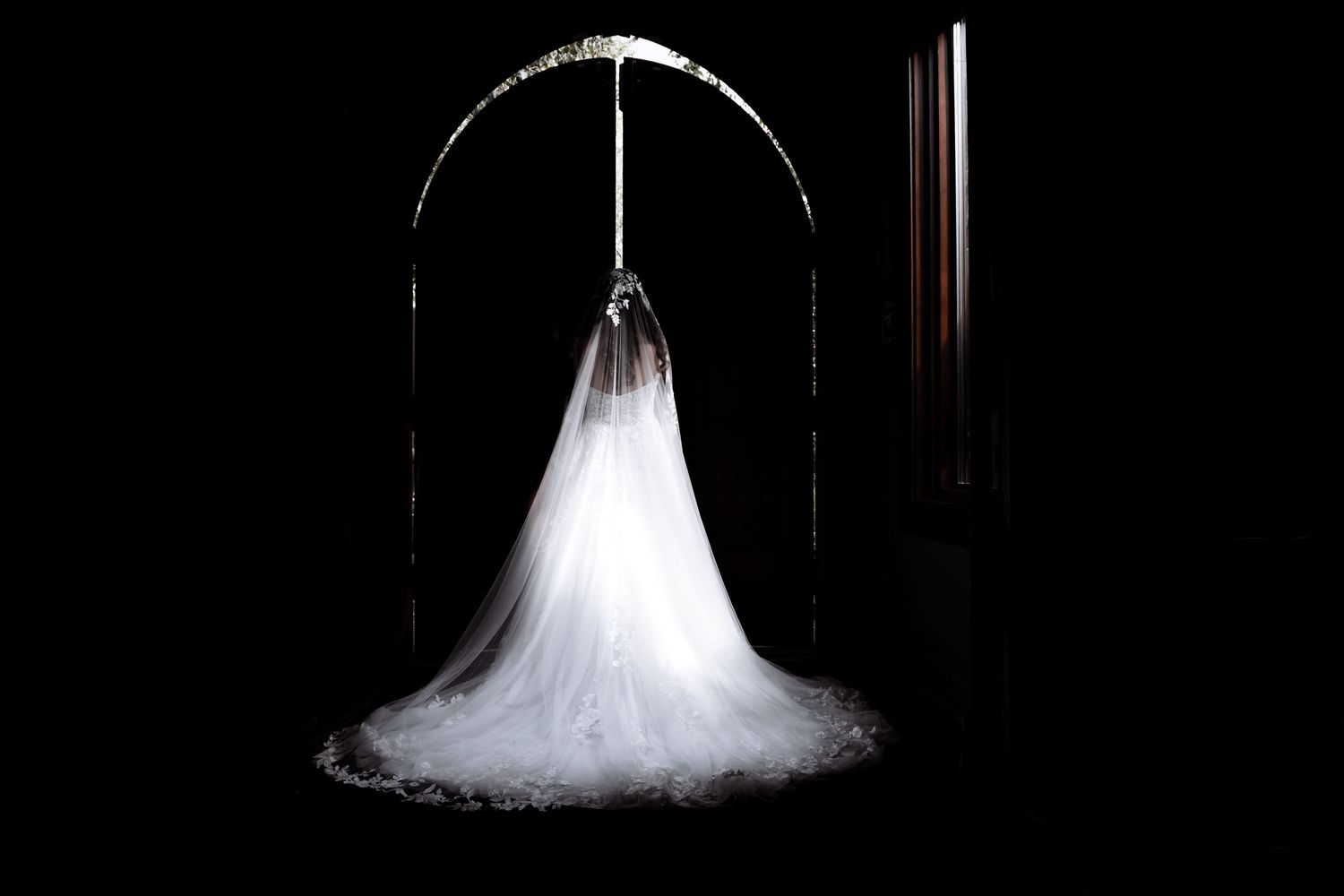 Elegant white wedding dress displayed by big doors