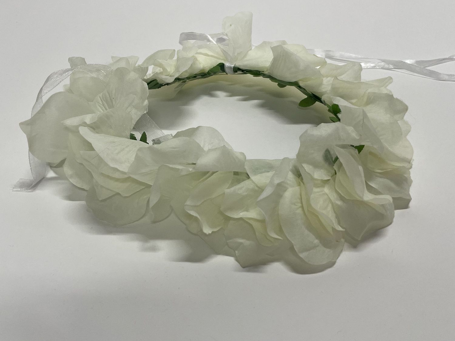 Ivory flower crown made with layered fabric petals on a green stem.