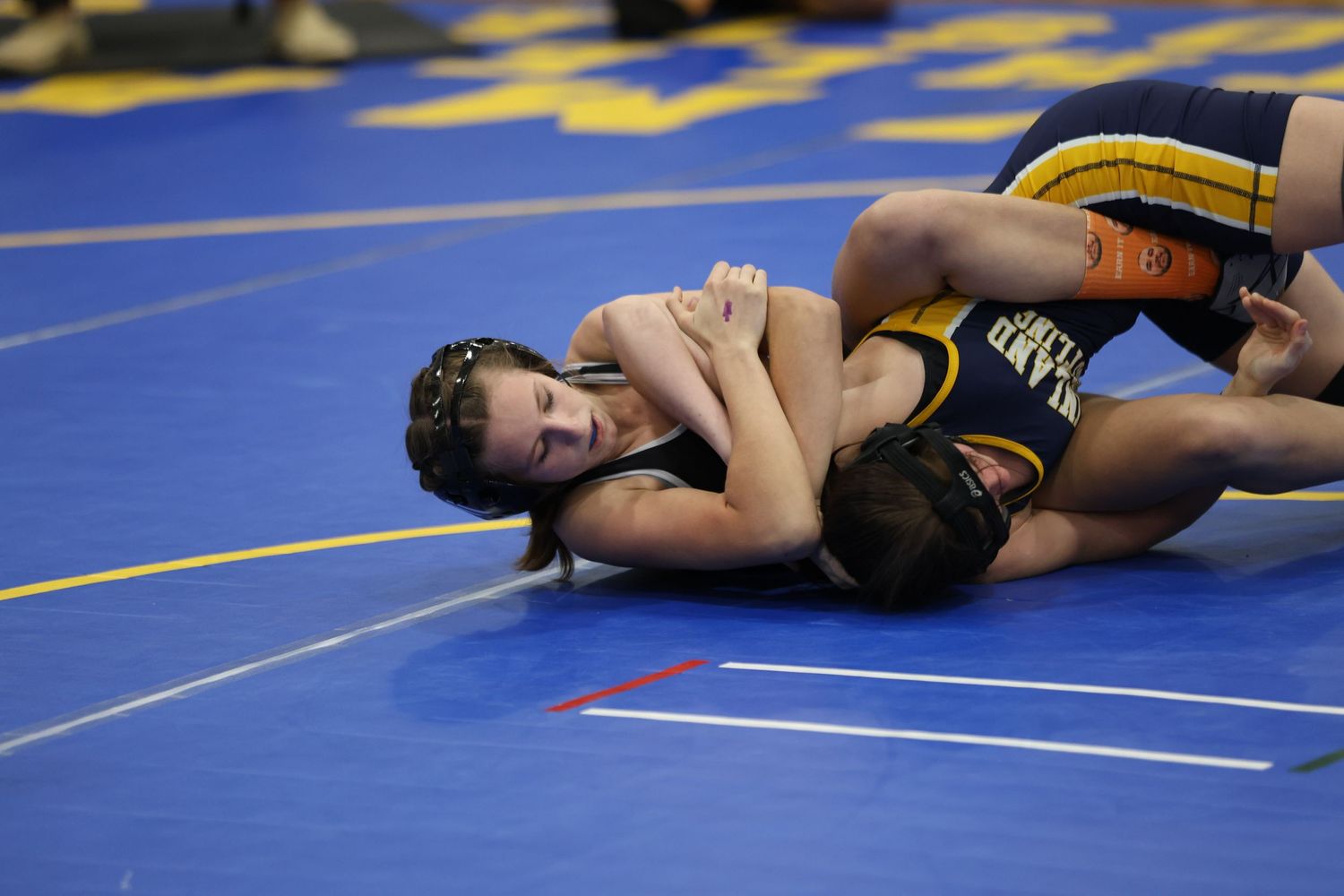 High school wrestlers competing during match on blue wrestling mat. Oviedo, Florida