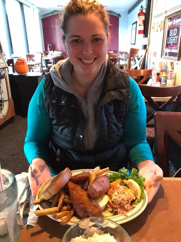 Restaurant dining scene with a large plate of french fries and sandwiches.