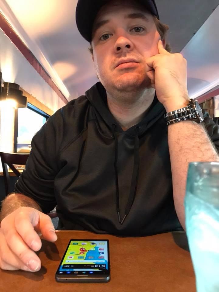Someone at a restaurant table looking at their smartphone.