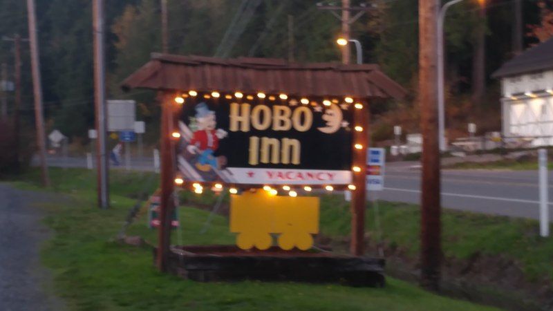 Illuminated Hobo's Inn sign outside at dusk.