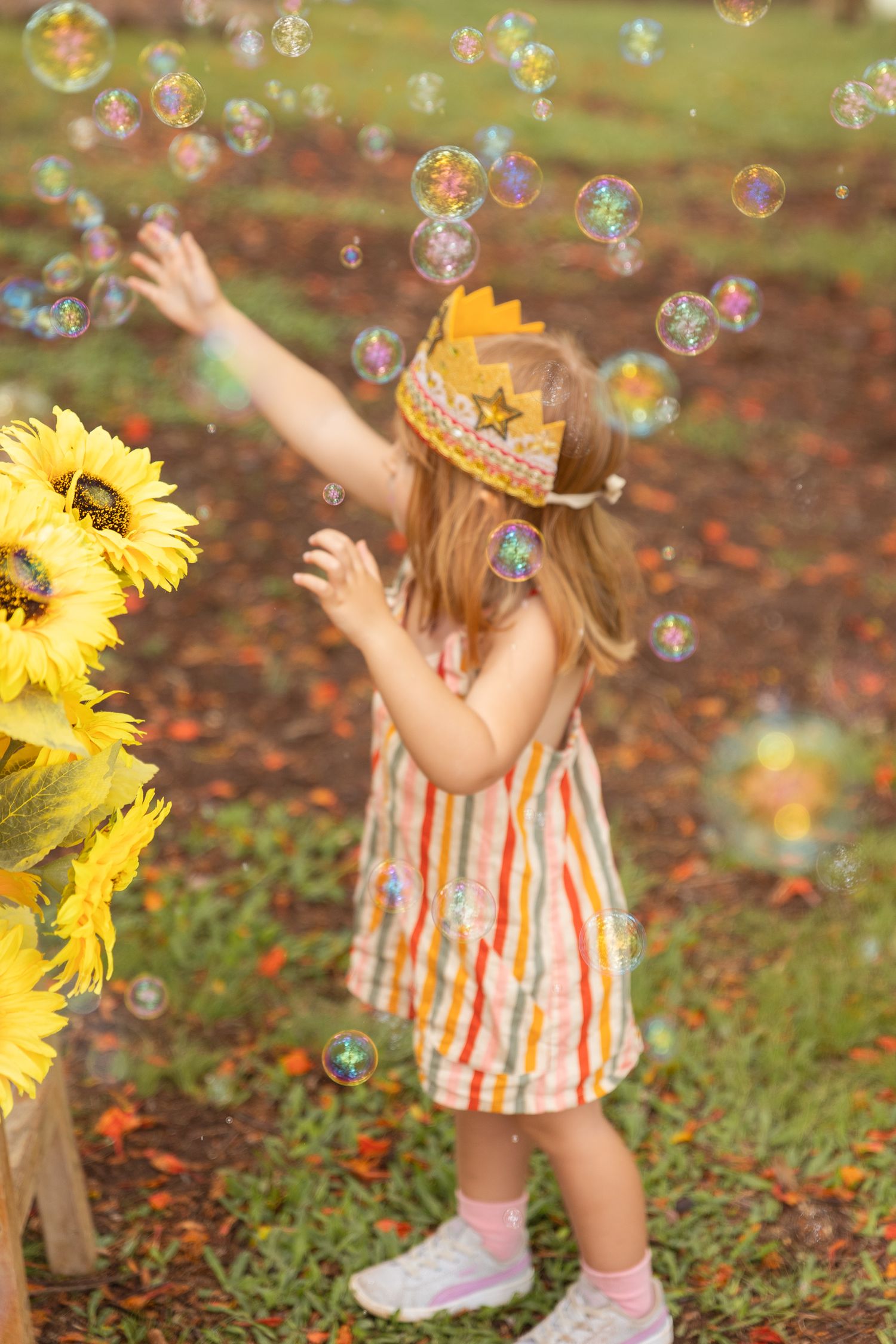 Playful scene with bubbles floating around sunflowers in an outdoor setting.