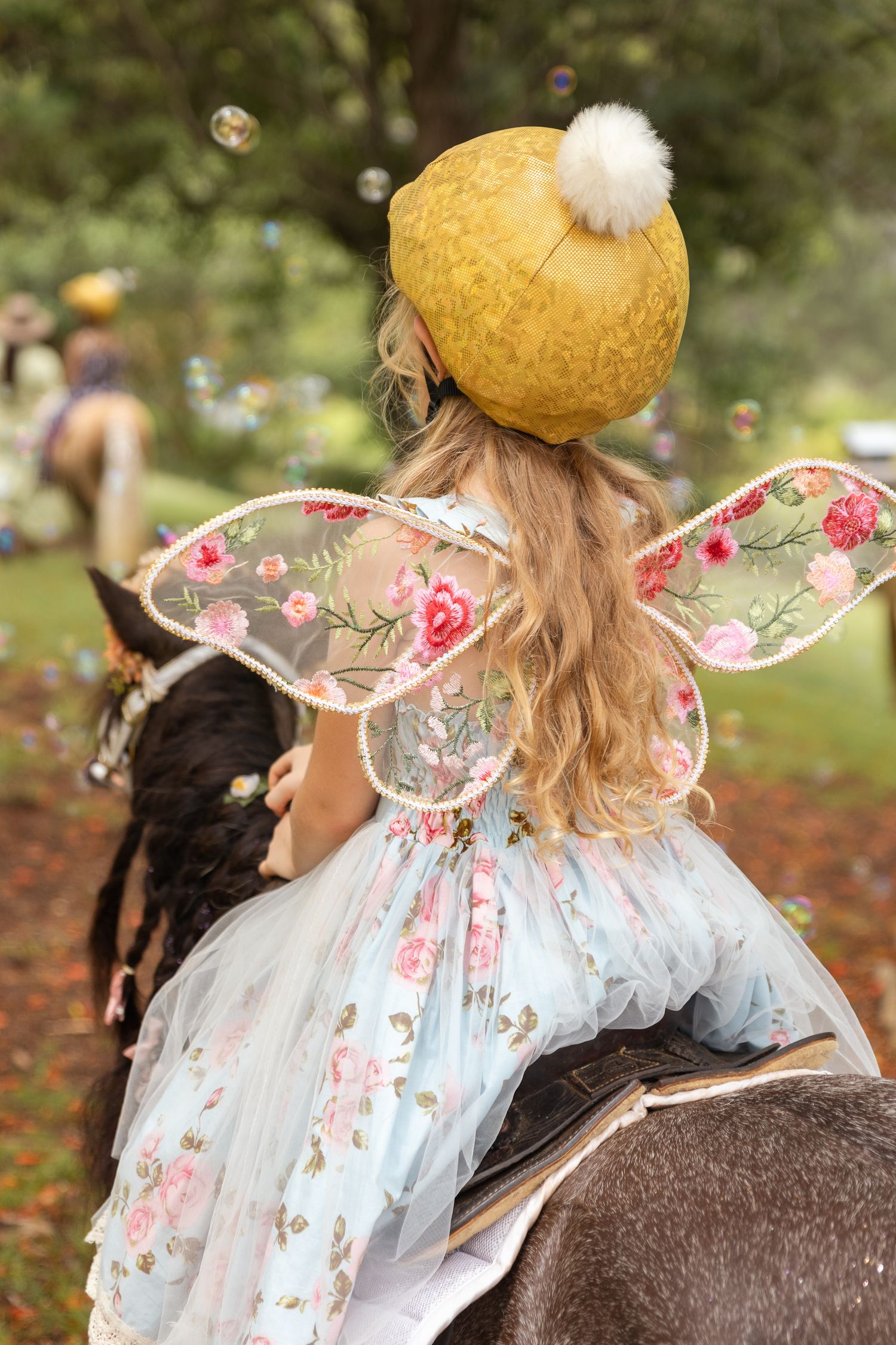 Enchanted garden scene with fairy wings and yellow beret accessories.