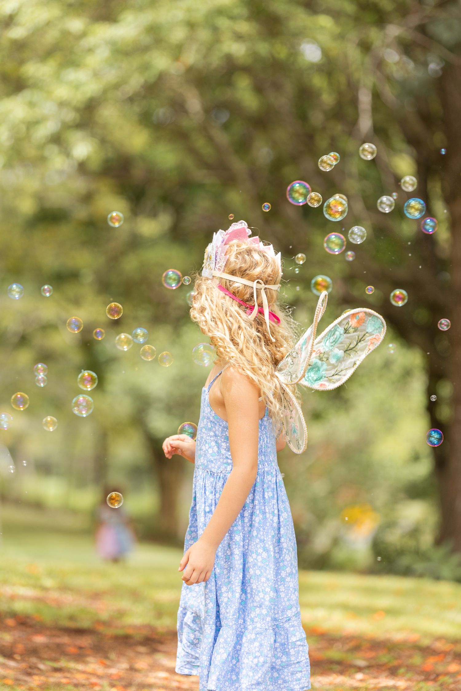 Magical outdoor scene with soap bubbles floating through sunlit trees.