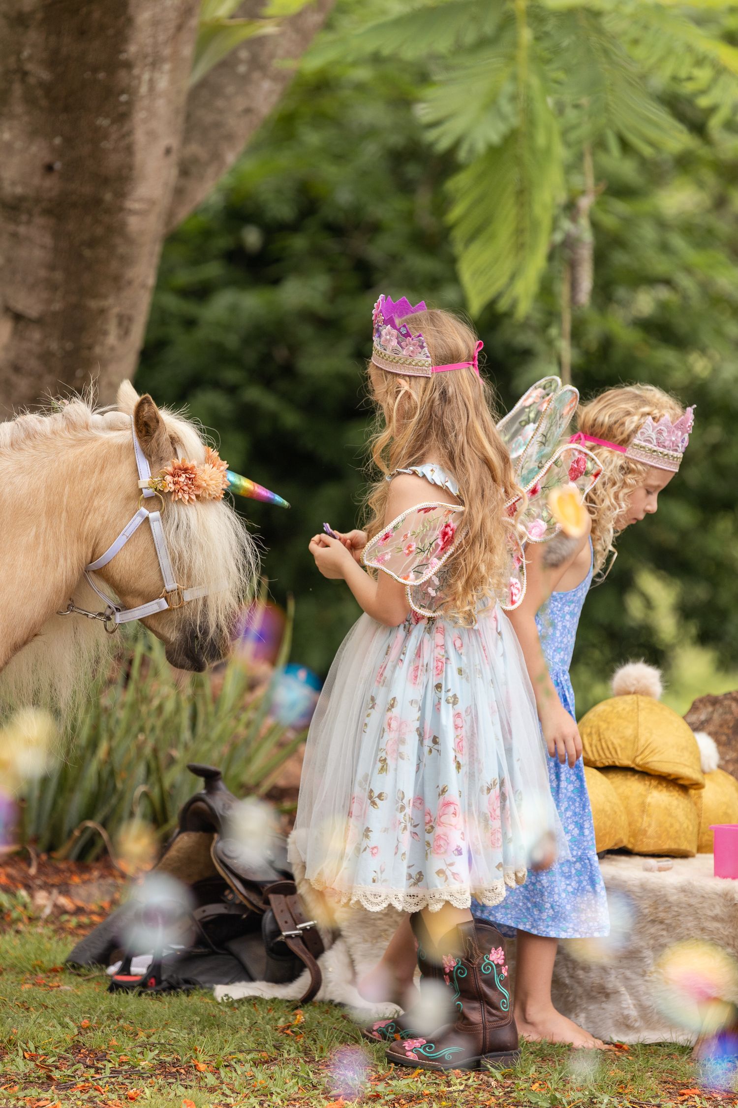 Whimsical fairy-themed garden party setup with decorative wings and bubbles.
