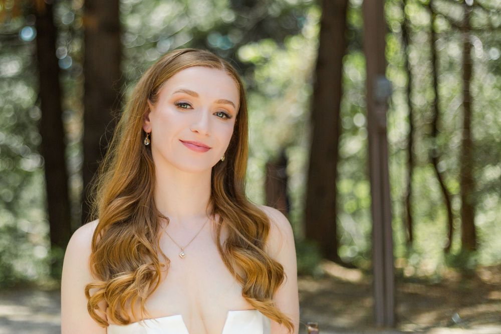 A wedding portrait in a forest setting with soft natural lighting and elegant styling.