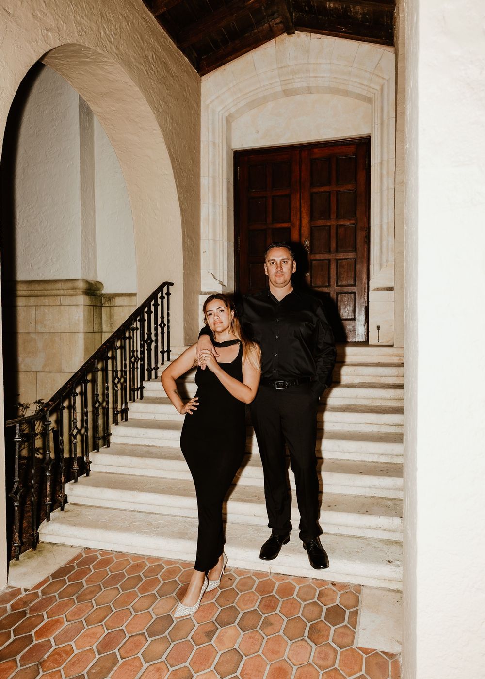 Creative dance poses on elegant white stone staircase with dark railings.